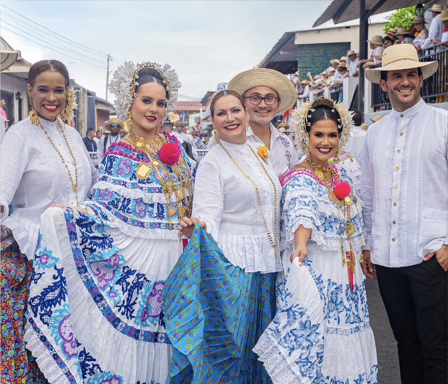 Grupo de hombres y mujeres con camisillas bordadas, basquiñas y polleras, en un patio colonial con sombreros panameños